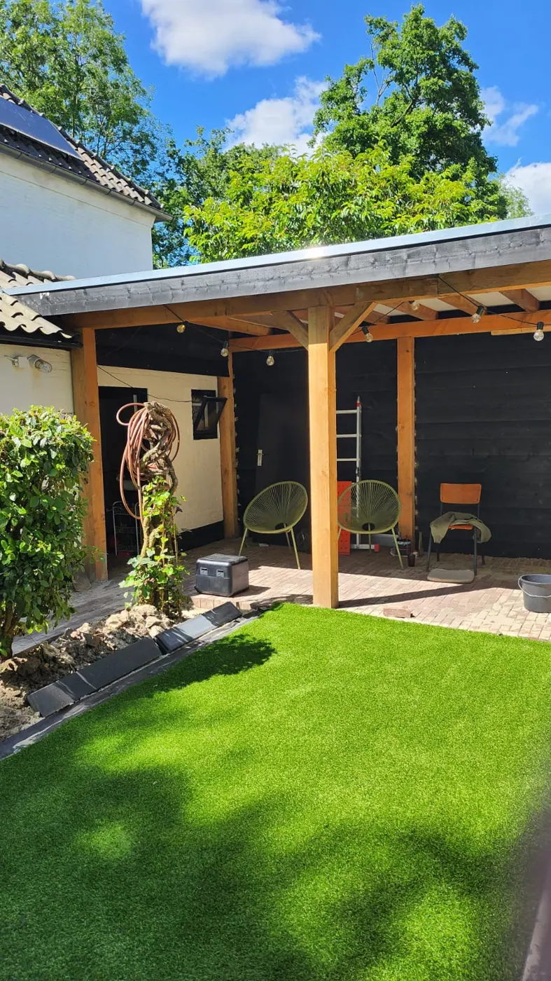 Houten overkapping met zitplek, terras en kunstgras