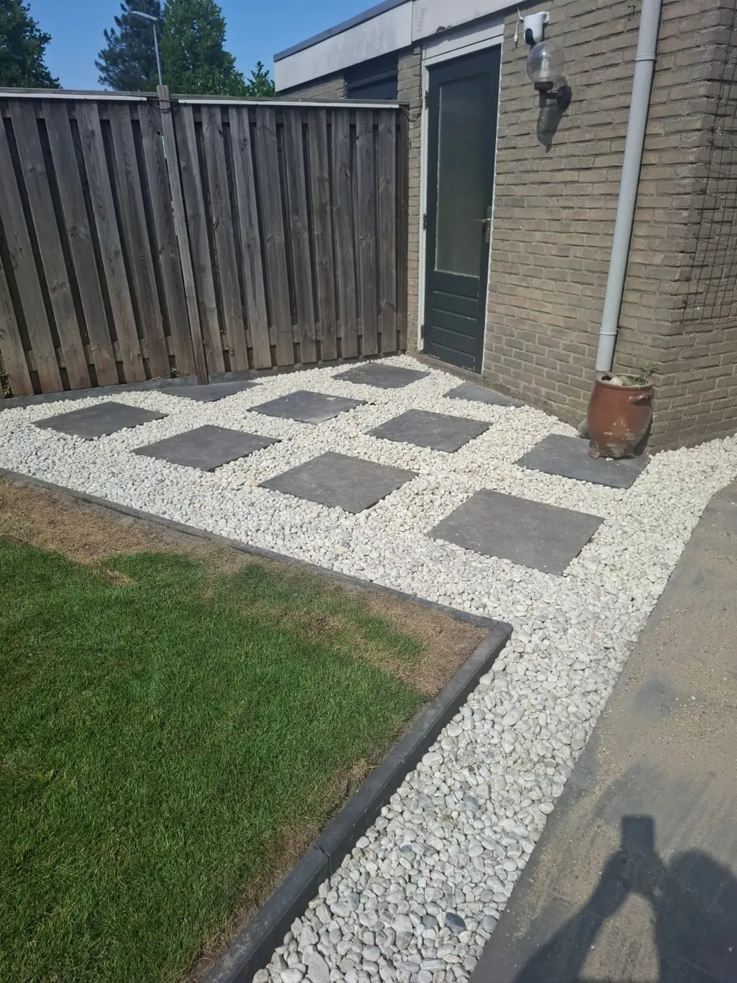 Staptegels in wit grind naast een gazon