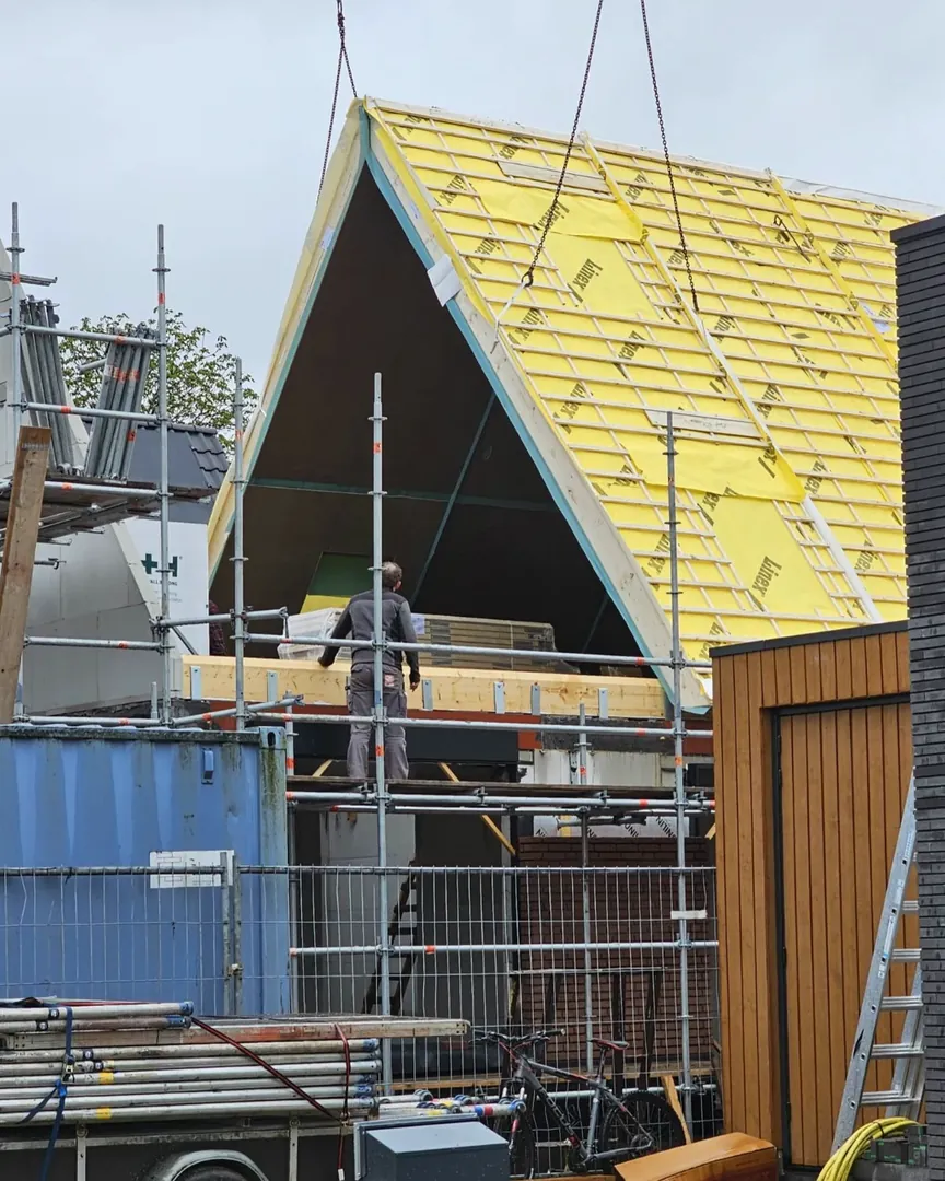 Schuin dak in opbouw met een vakman op de steiger, eigen werk van Bouwpartners Eindhoven